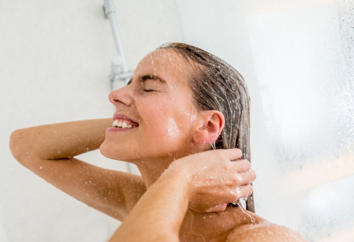 Happy woman taking a shower and relaxing