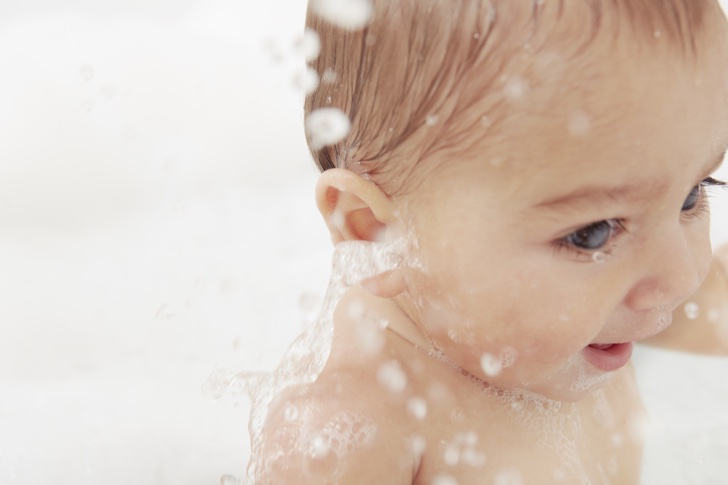Baby splashing in bathtub